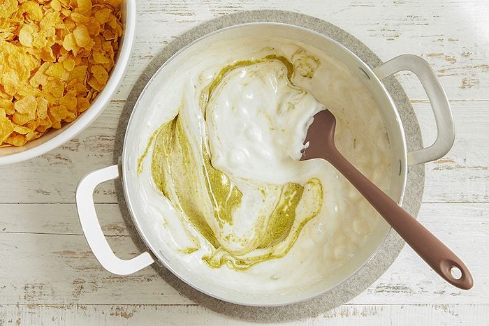 Butter and marshmallows are melted together in a pot and stirred until smooth and glossy.