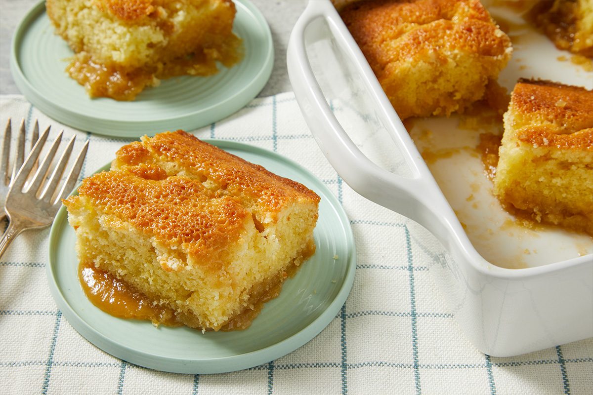A horizontal image shows plated servings of pudding on small dishes with sauce surrounding each piece.