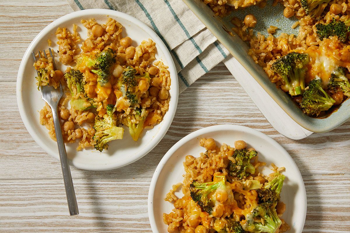 A horizontal overhead image shows portions of the casserole served on plates with visible broccoli, chickpeas, and melted cheese.