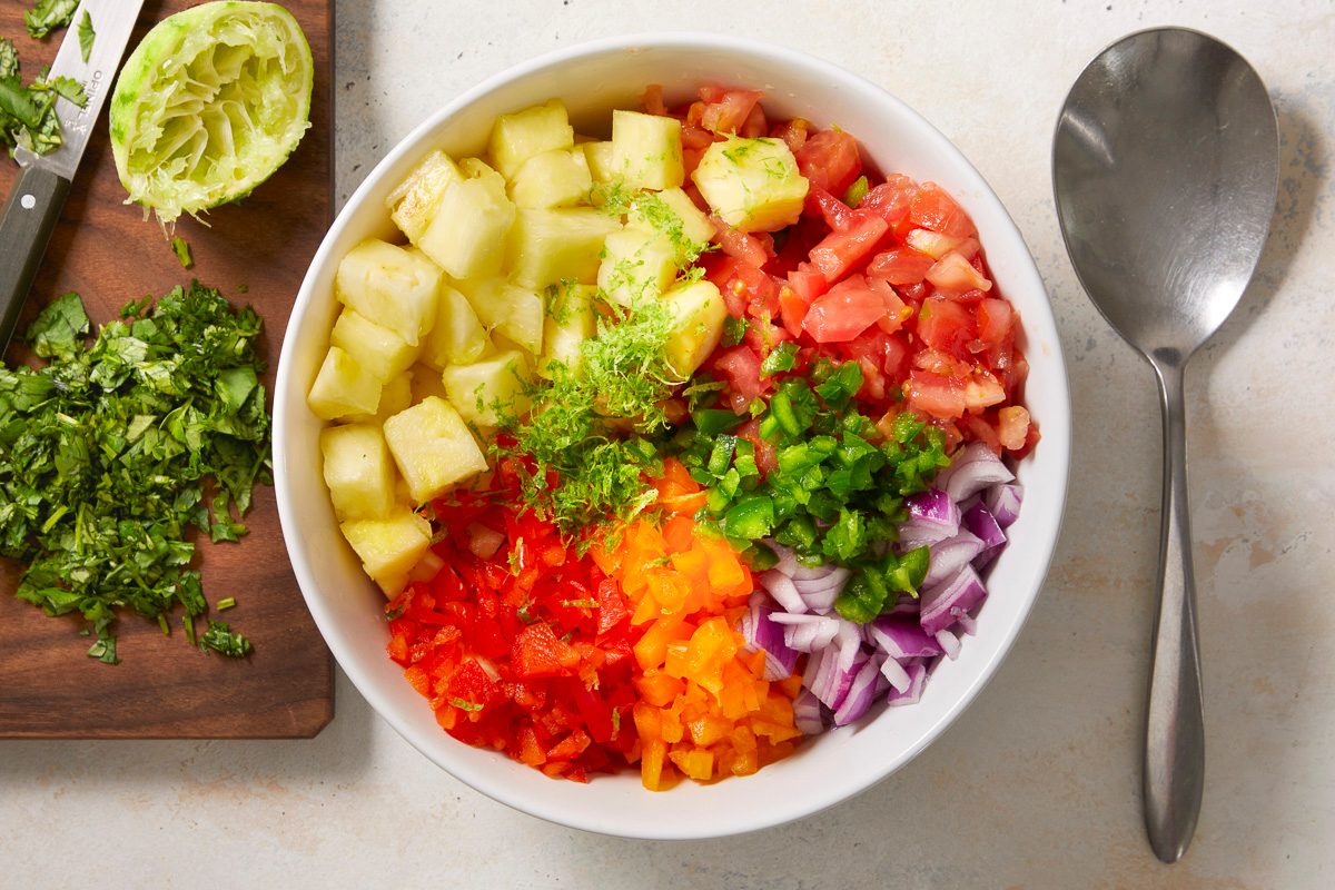pineapple, tomatoes, peppers, red onion, jalapeno, cilantro and lime zest and juice combined in a large bowl
