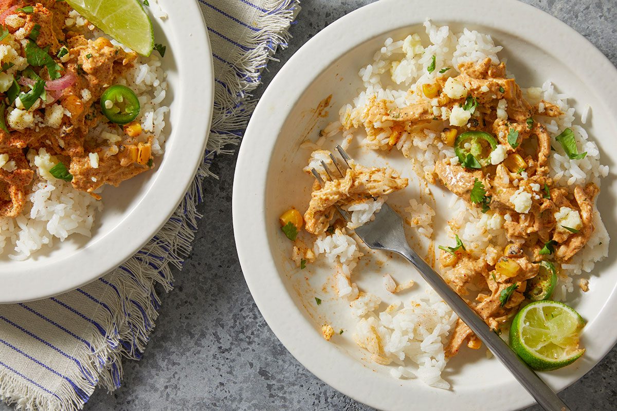 Overhead horizontal push and pulls image of partially eaten street corn chicken bowl showing texture and creamy consistency.