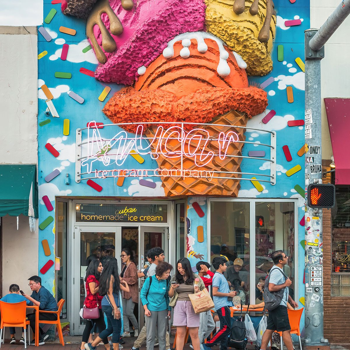 People stand in front of an ice cream shop in Little Havana quarter, Miami, Florida, USA on a cloudy day.