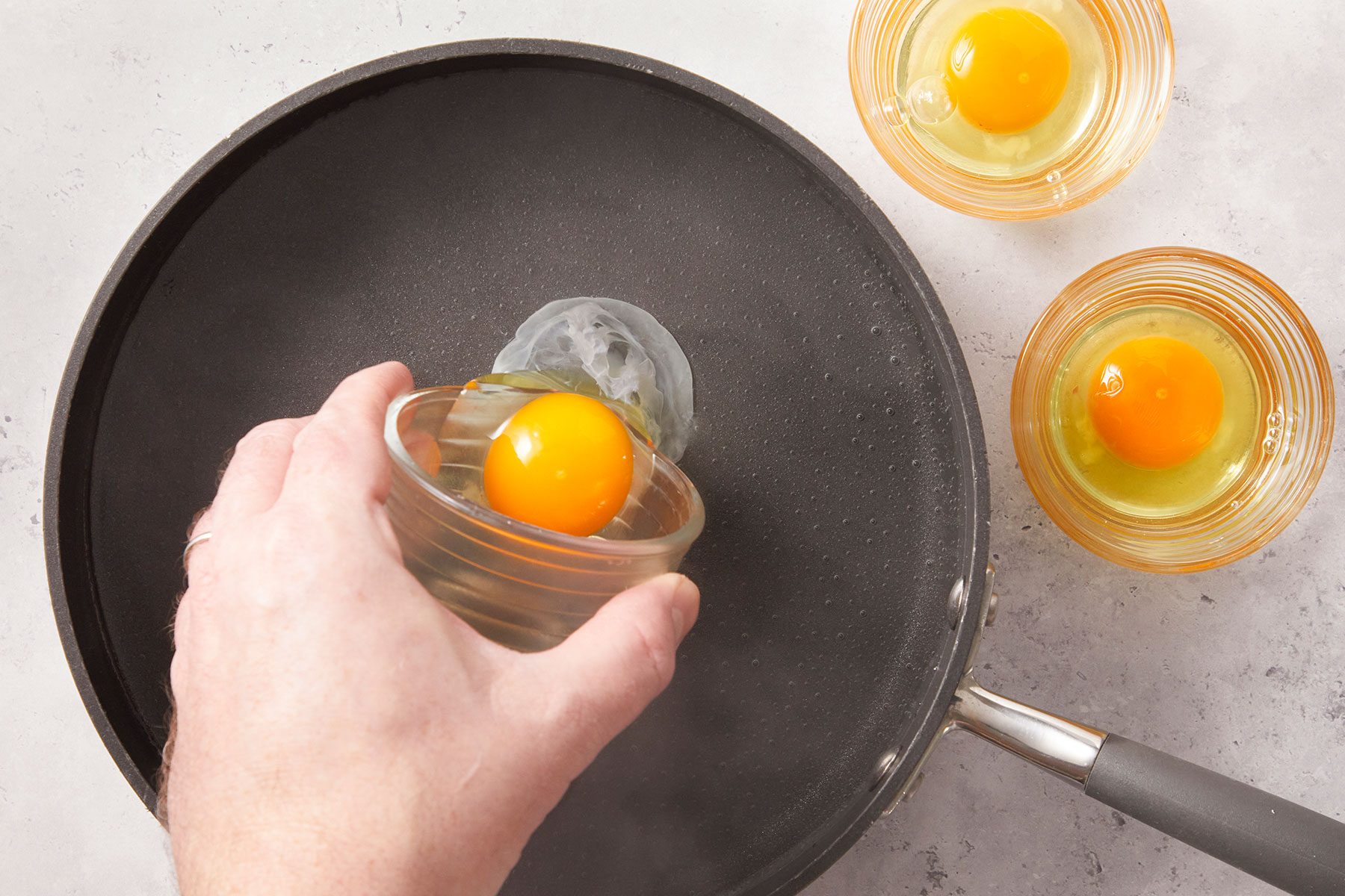 adding egg in bolied water to make poached eggs