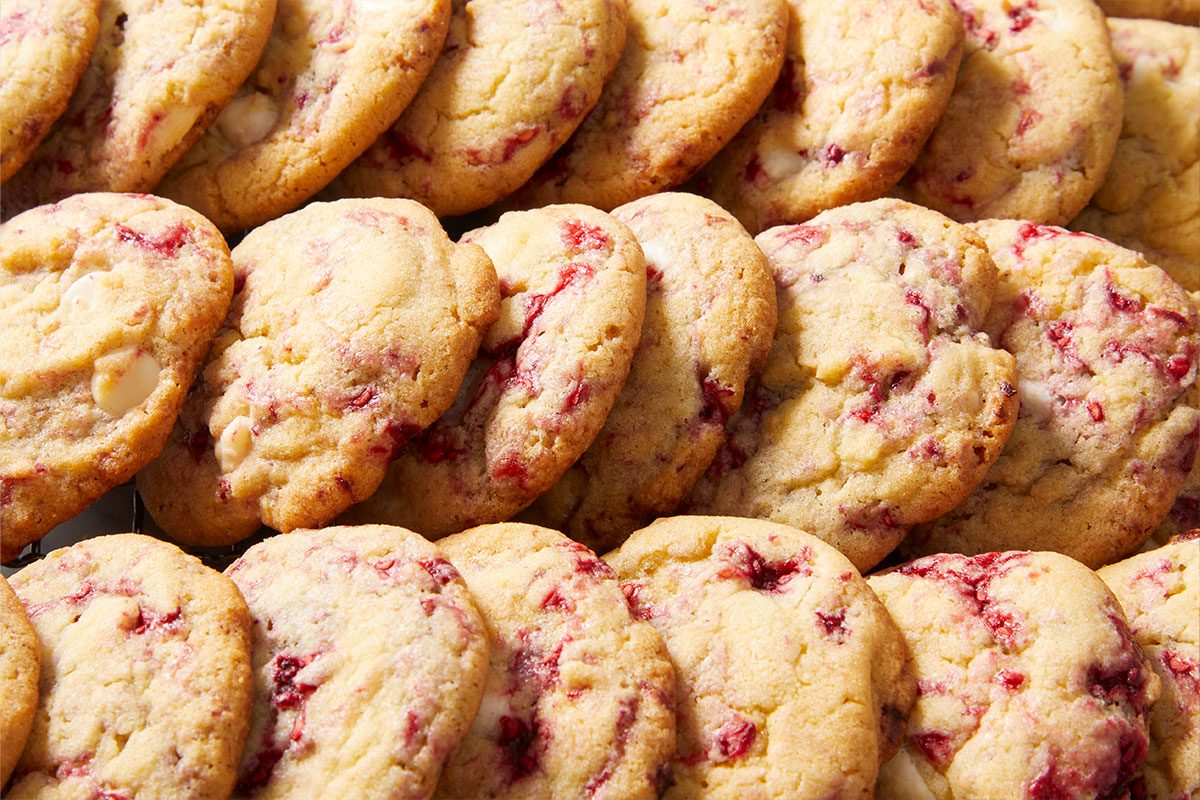 Eye-level horizontal close-up of cookies showing raspberry pieces and white chocolate chips.