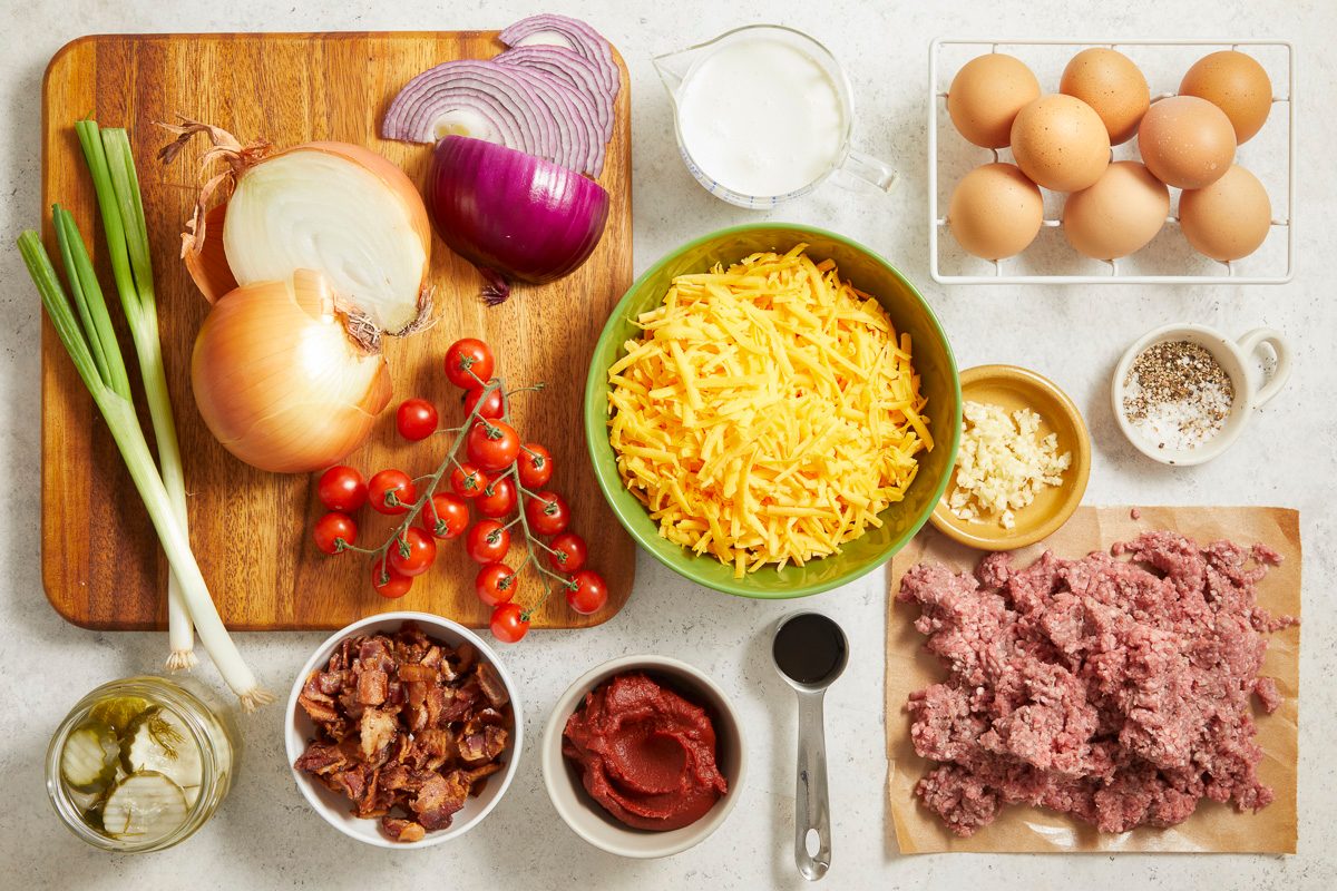 Overhead horizontal step-by-step image of assembled ingredients including ground beef, bacon, cheese, eggs, onion, and seasonings for casserole preparation.
