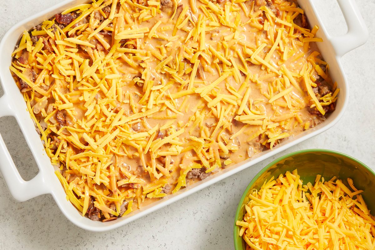 Overhead horizontal step-by-step image of casserole dish topped with shredded cheddar cheese before baking.