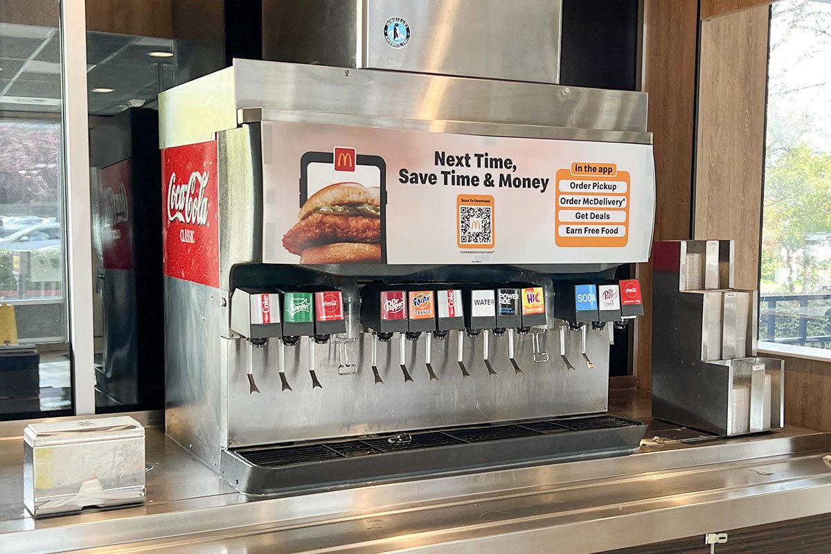 Interior of a McDonald's restaurant featuring a self-serve beverage station with promotional signage