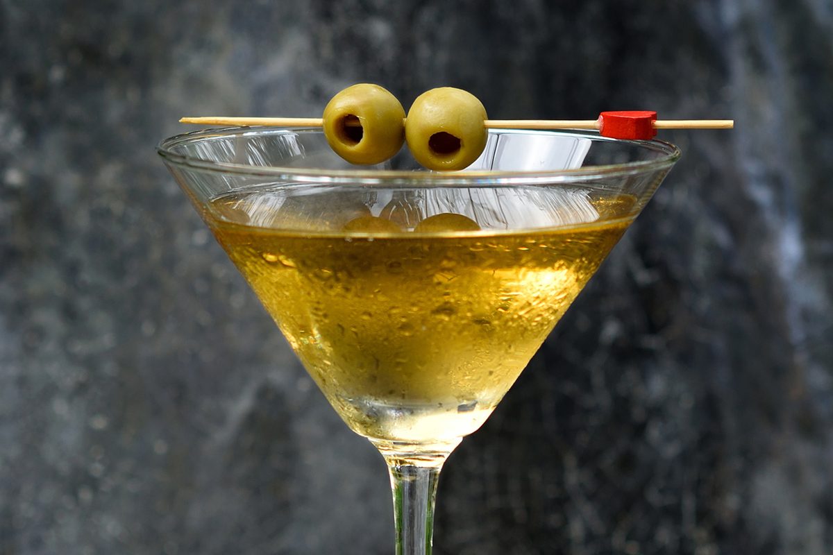 cocktail in a martini glass with olives on top