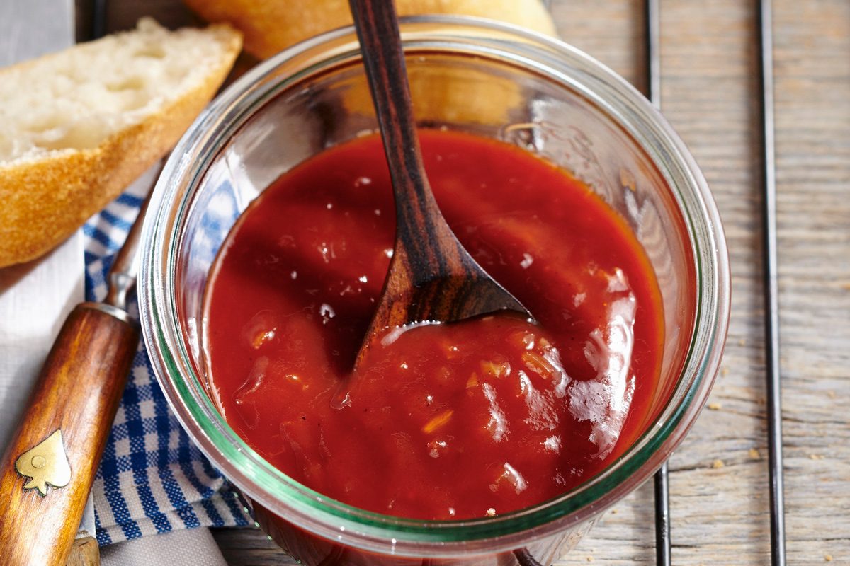 top angle close up of Florida Citrus Bbq Sauce in a small glass bowl with a spoon in it