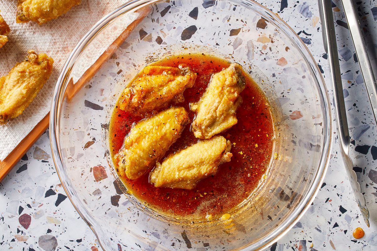 chicken wings in a bowl of red fish sauce