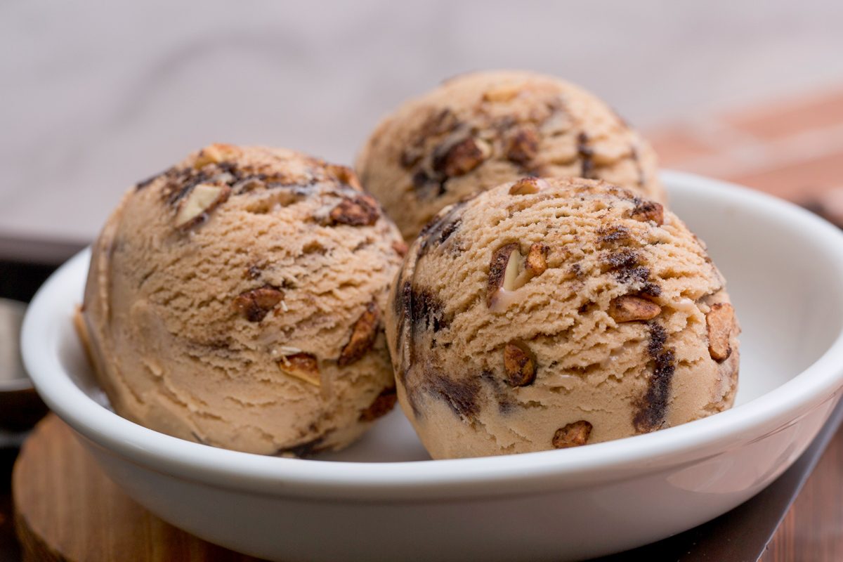 chocolate ice cream with chocolate chips and nuts in a white bowl
