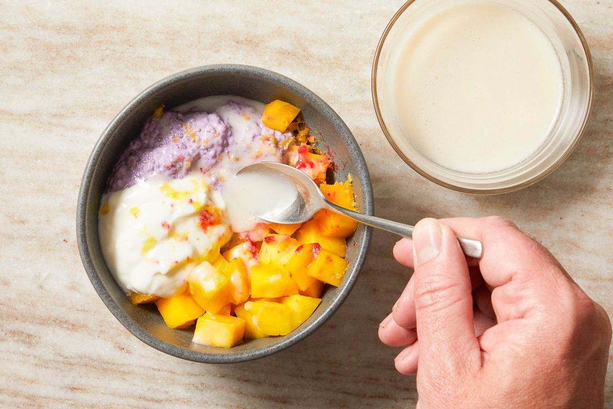 coconut drizzle being added to fruit bowl