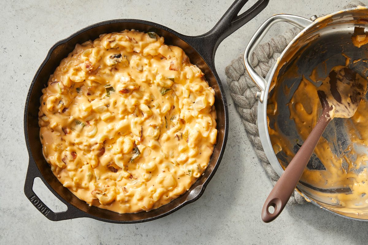 Overhead horizontal image of a cast iron skillet filled with creamy macaroni and cheese.