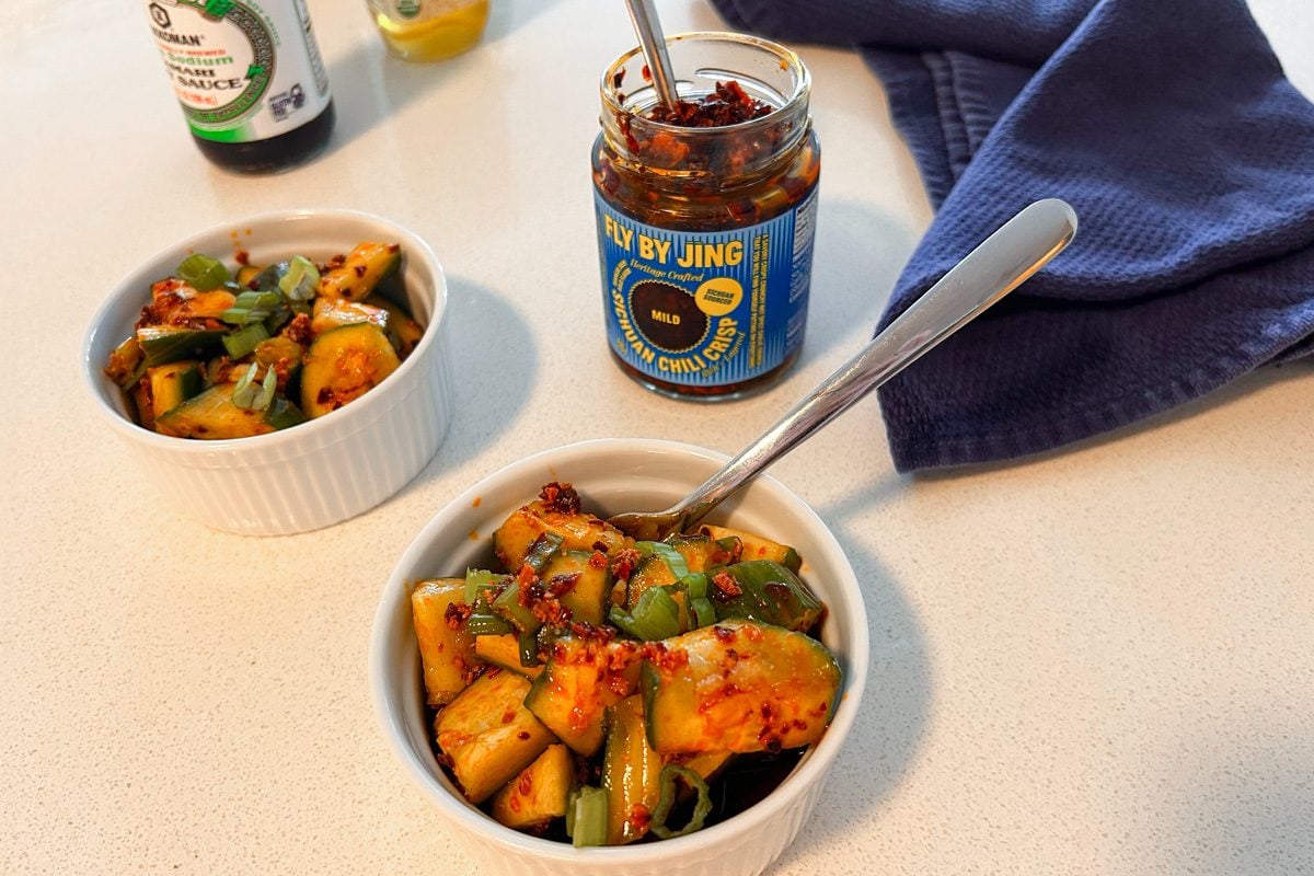 jar of Fly By Jing Mild Sichuan Chili Crisp begins a bowl of smashed chili crisp cucumber salad
