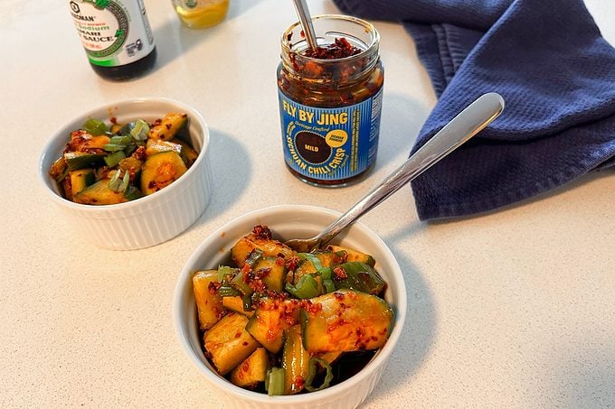 jar of Fly By Jing Mild Sichuan Chili Crisp begins a bowl of smashed chili crisp cucumber salad