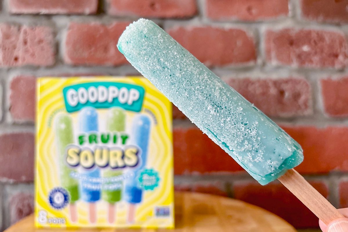close up of popsicle covered with granulated sugar and citric acid mixture with box in the background