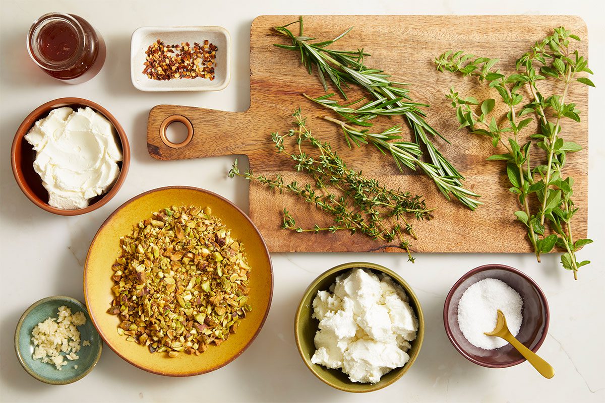 Fresh vegetables and herbs arranged on a wooden cutting board, ready for salad preparation.