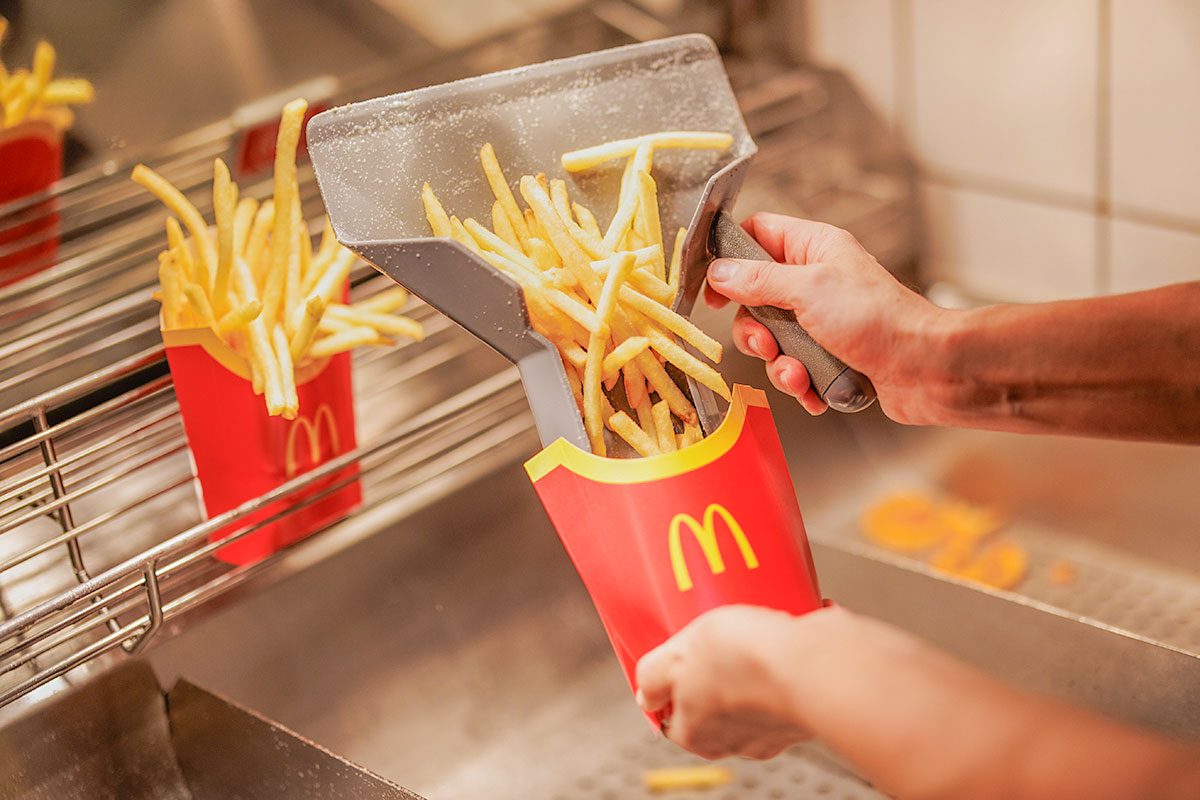 An employee fills a bag with French fries
