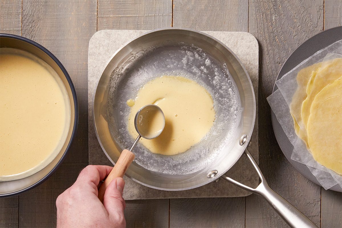 Overhead step-by-step food photography showing crepe batter being poured and cooked in a skillet to form thin crepe noodles for manicotti.