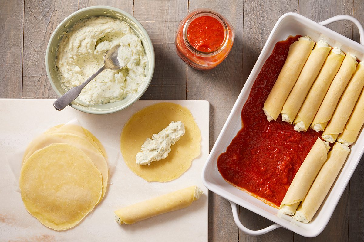 Overhead step-by-step food photography showing crepe noodles filled with ricotta mixture and arranged with sauce before baking Homemade Manicotti.
