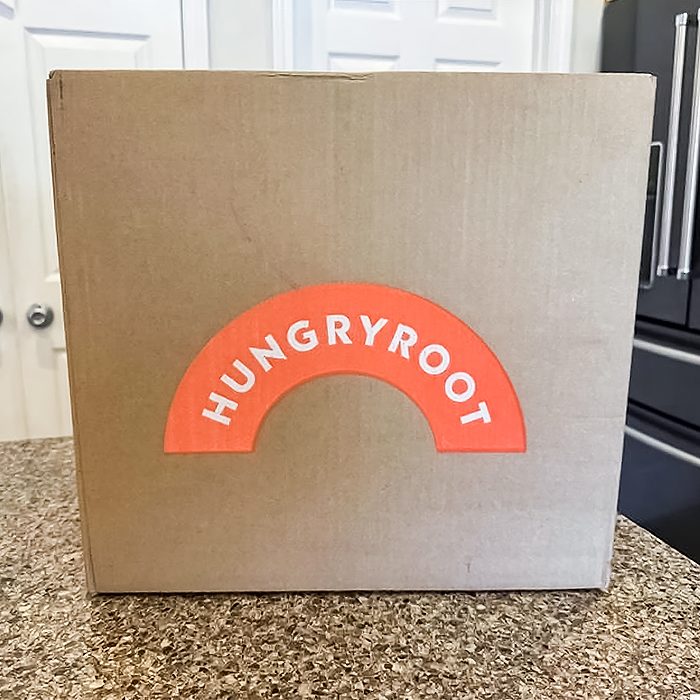 A brown cardboard box with an orange semicircle label reading 
