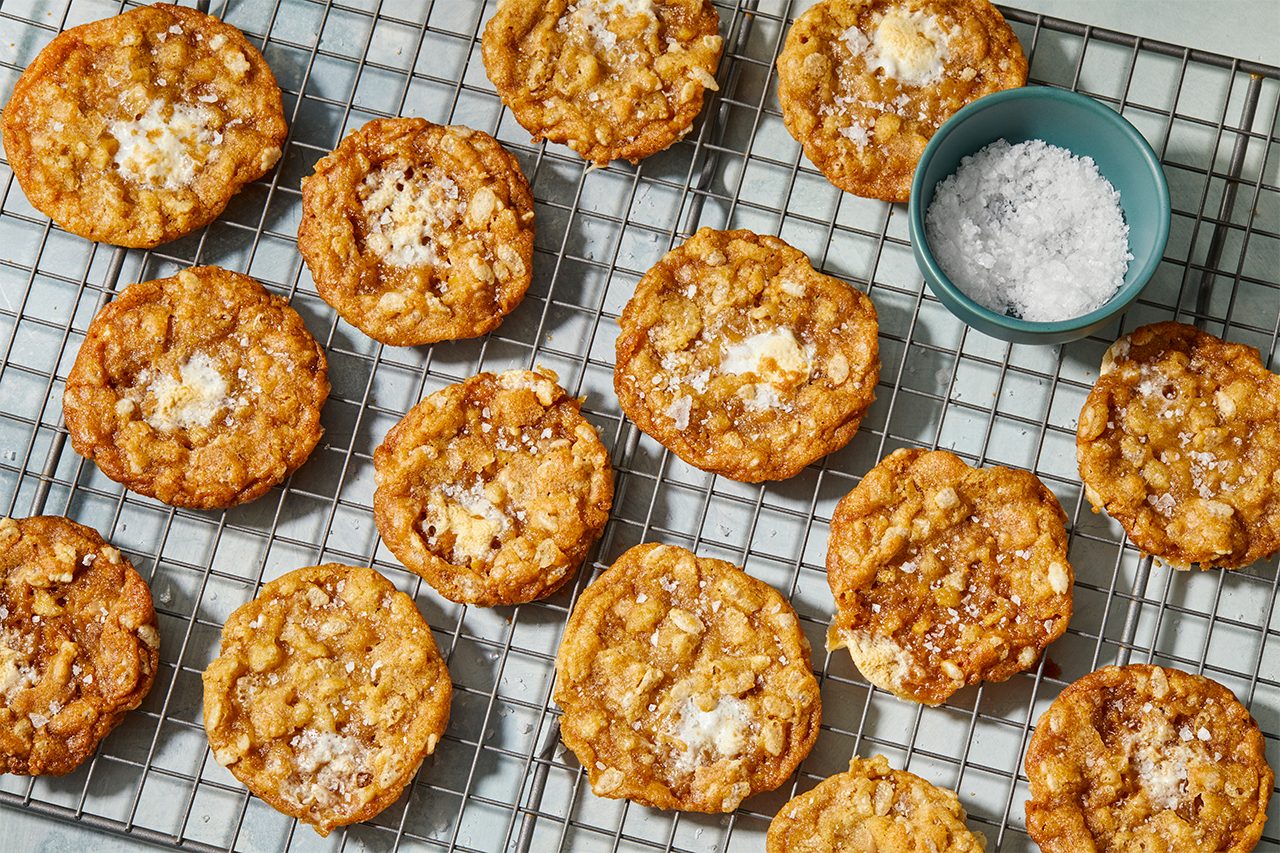 Overhead view of marshmallow crispy cookies on a baking sheet, showing golden edges and visible cereal, marshmallow, and toffee pieces.