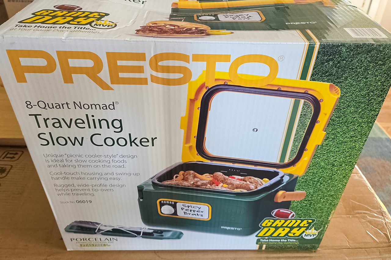 Box of a Presto 8-Quart Nomad Traveling Slow Cooker, showing an image of the slow cooker with food inside and a football field design on the packaging.