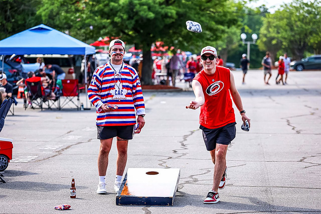 Fans playing cornhole at a tailgate party